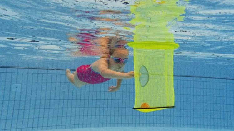 pływający- kosz-z- piłkami-w-basenie-dziewczynka-podpłpywa-do-kosza.jpg
