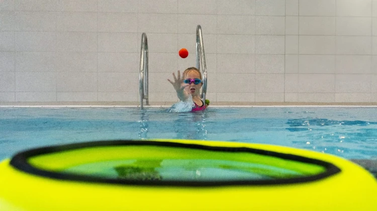 pływający- kosz-z- piłkami-w-basenie-dziewczynka-rzuca-piłkę-do-kosza.jpg