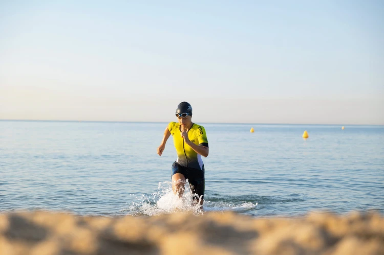 strój-triathlonowy-zółto-czarny-krótki-rękaw-kobieta-wychodzi-z-wody.jpg